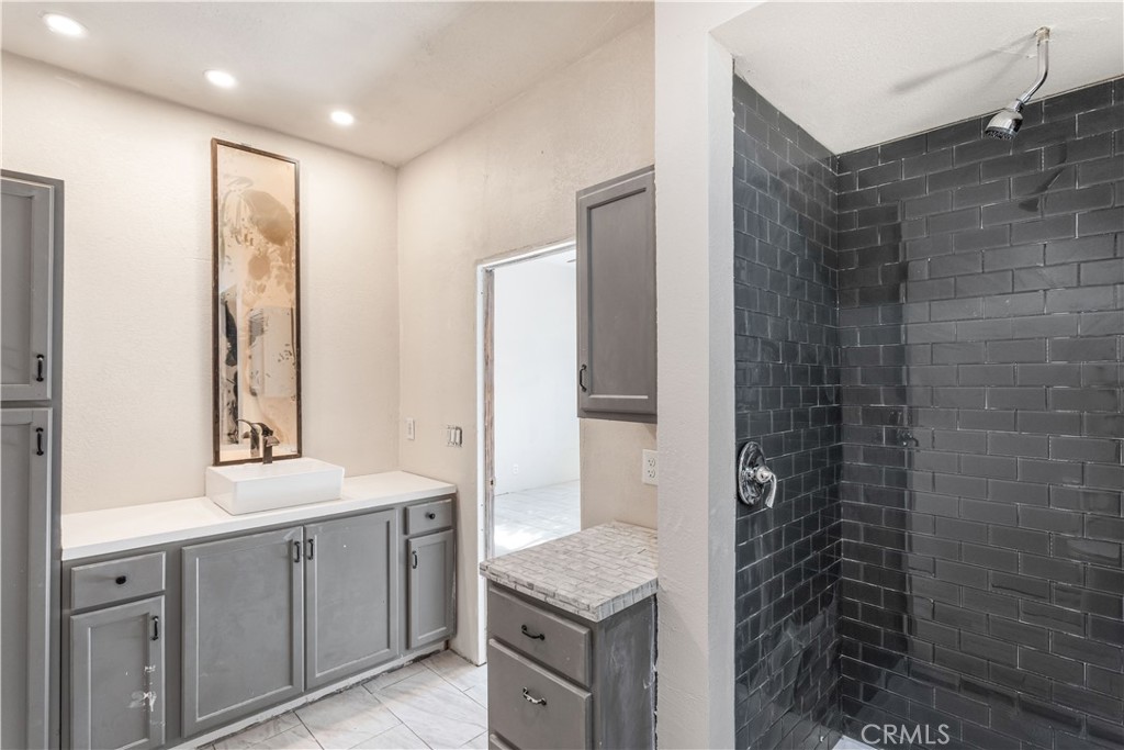 2311 Rose Road Fallbrook, CA 92028 - Photo 33 of 50 a bathroom with a granite countertop sink a mirror and a shower