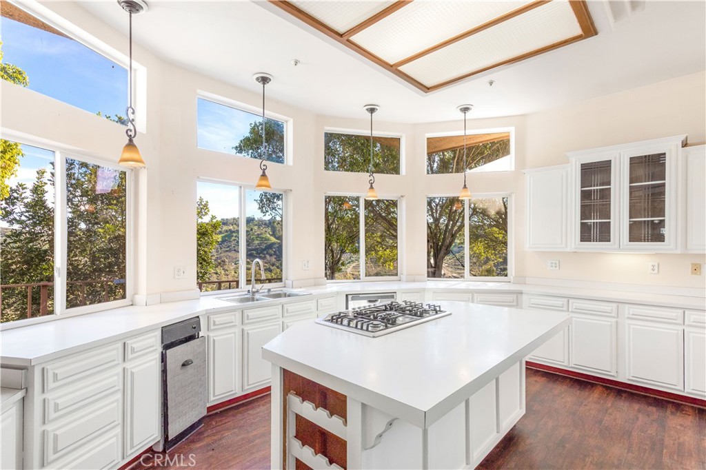 2311 Rose Road Fallbrook, CA 92028 - Photo 7 of 50 a kitchen with a sink and white cabinets with wooden floor