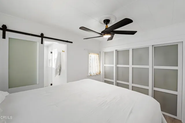 a bedroom with a large bed and a chandelier