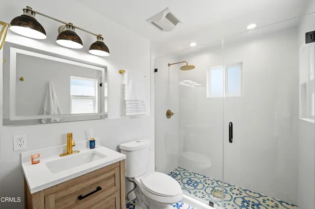 a bathroom with a sink a toilet and shower