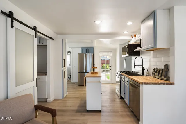a kitchen with stainless steel appliances granite countertop a sink stove and refrigerator