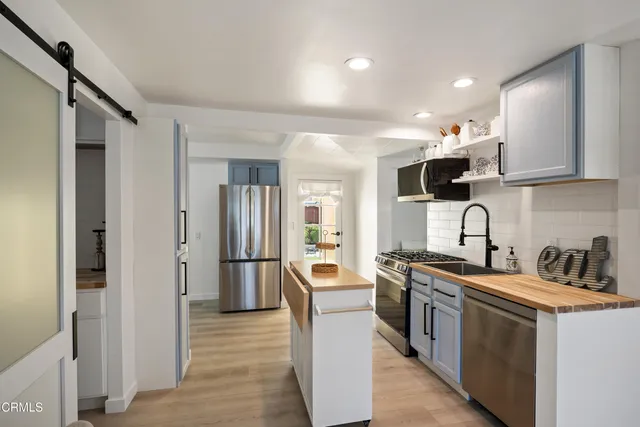 a kitchen with stainless steel appliances granite countertop a sink stove and refrigerator
