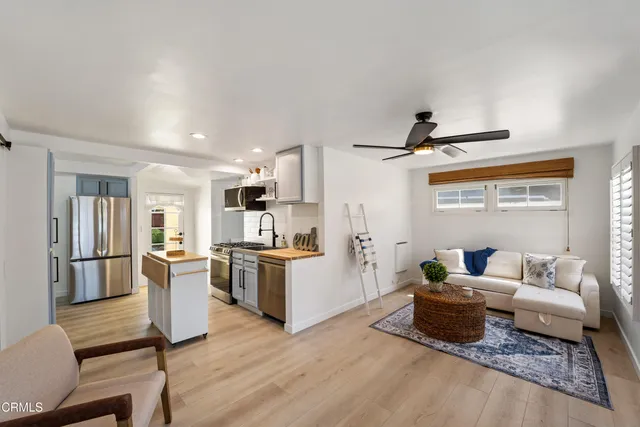 a living room with furniture and a kitchen view