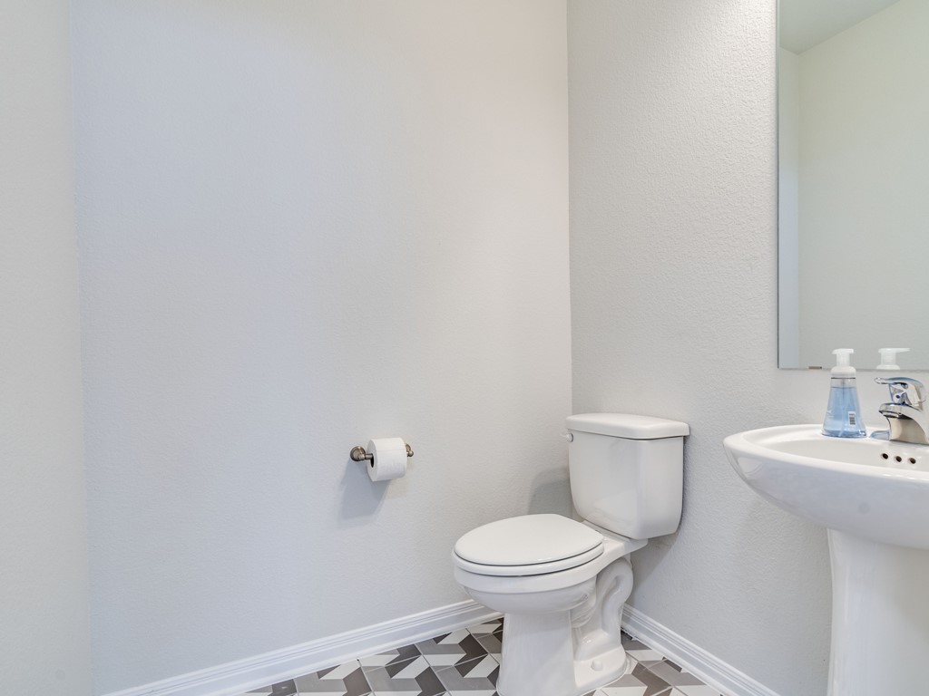 4113 Birdwatch Loop, Unit 21 Pflugerville, TX 78660 - Photo 13 of 30 a white toilet sitting next to a bathroom sink