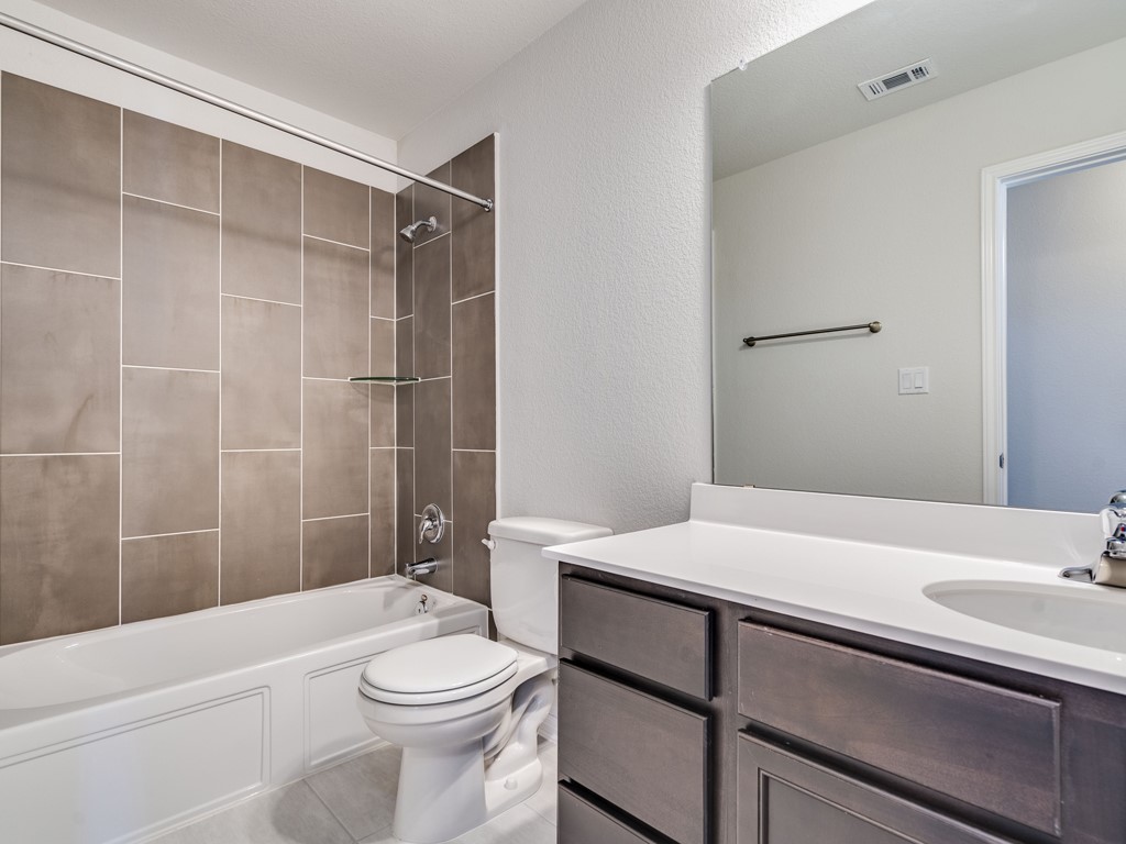 4113 Birdwatch Loop, Unit 21 Pflugerville, TX 78660 - Photo 22 of 30 a bathroom with a sink a toilet and shower