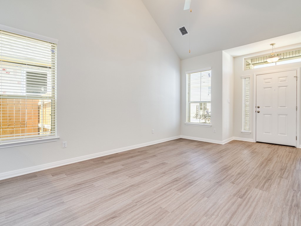 4113 Birdwatch Loop, Unit 21 Pflugerville, TX 78660 - Photo 4 of 30 an empty room with wooden floor and windows