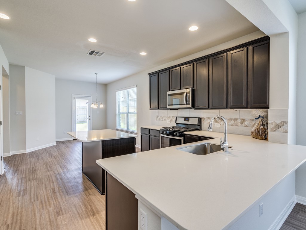4113 Birdwatch Loop, Unit 21 Pflugerville, TX 78660 - Photo 5 of 30 a kitchen with sink a microwave and refrigerator