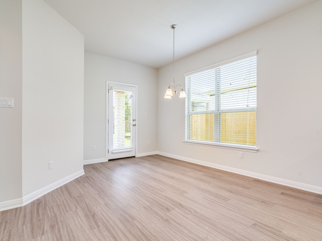 4113 Birdwatch Loop, Unit 21 Pflugerville, TX 78660 - Photo 8 of 30 an empty room with wooden floor and windows