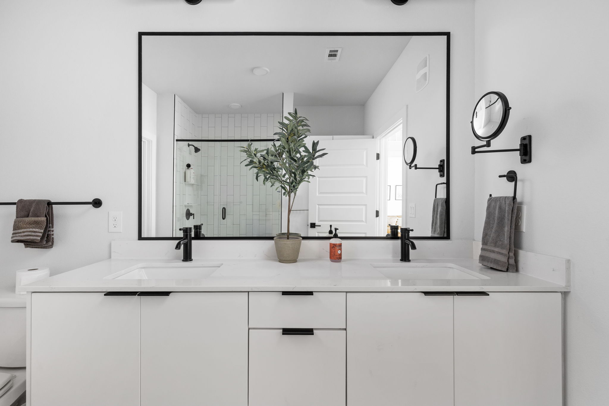 2500 Longview Street, Unit 507 Austin, TX 78705 - Photo 23 of 37 Double vanities with quartz countertops and sleek black fixtures elevate this contemporary primary bathroom.