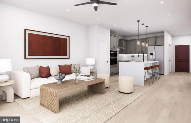 a living room with furniture a refrigerator and kitchen view