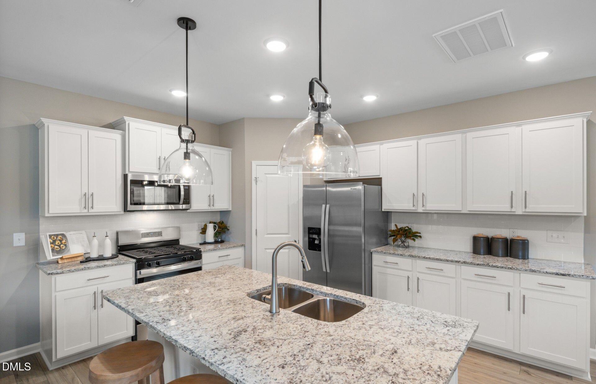500 Havannah Road Garner, NC 27529 - Photo 5 of 22 a kitchen with stainless steel appliances granite countertop a sink refrigerator a stove a microwave and island