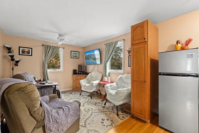 a living room with furniture wooden floor and a window
