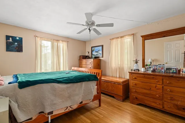 a bedroom with a bed and large windows