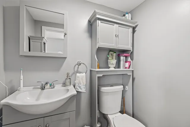 a bathroom with a toilet sink and mirror