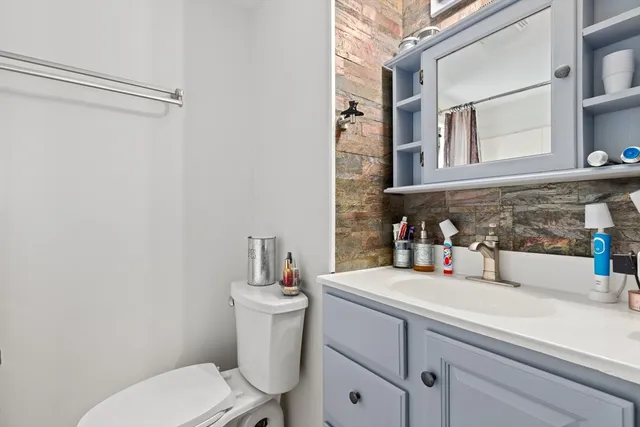 a bathroom with a toilet sink and mirror