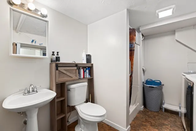 a bathroom with a sink a toilet and a mirror