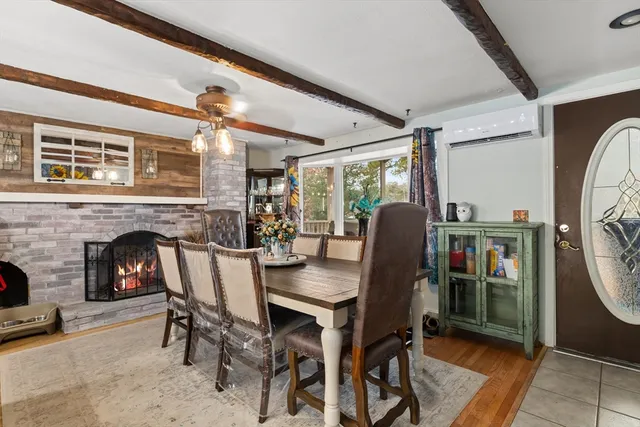 a dining room with furniture a fireplace and wooden floor