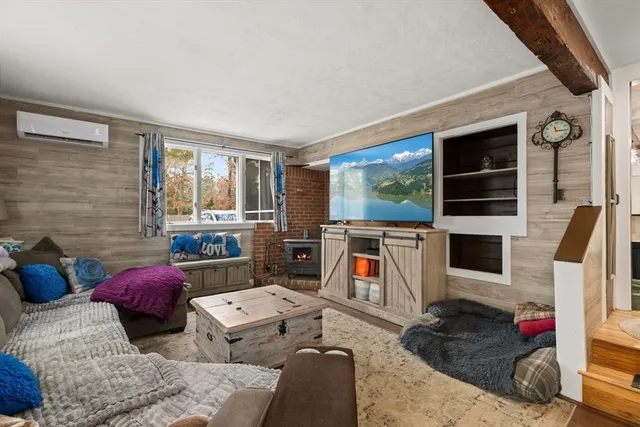 a bedroom with furniture a flat screen tv and a fireplace