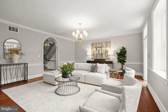 a living room with furniture a chandelier and a dining room
