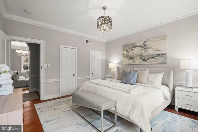 a bedroom with a large bed and a chandelier