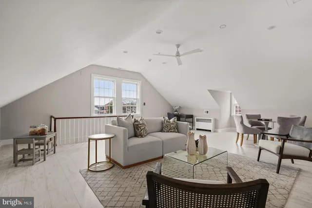 a living room with furniture a rug and white walls