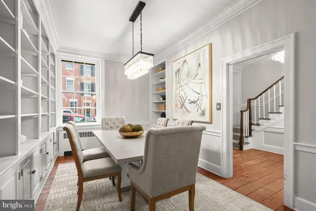 a dining room with furniture a chandelier and wooden floor