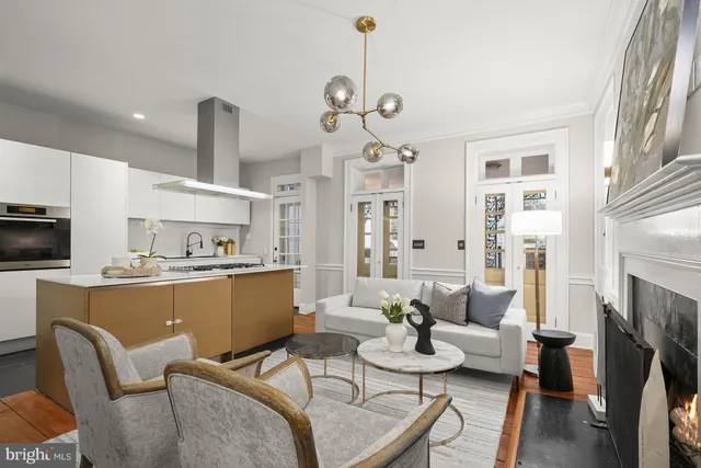 a living room with furniture a fireplace a flat screen tv and kitchen view