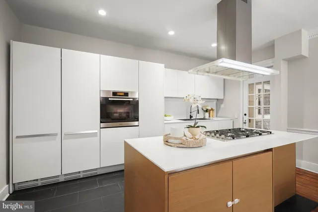 a kitchen with a sink a stove and white cabinets