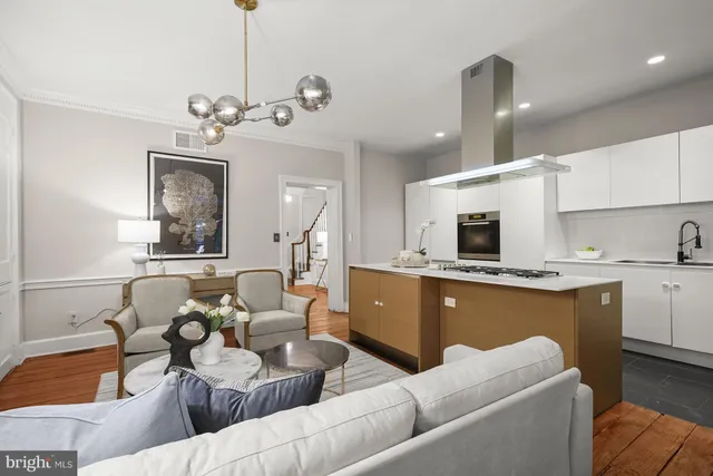 a living room with furniture kitchen and a chandelier