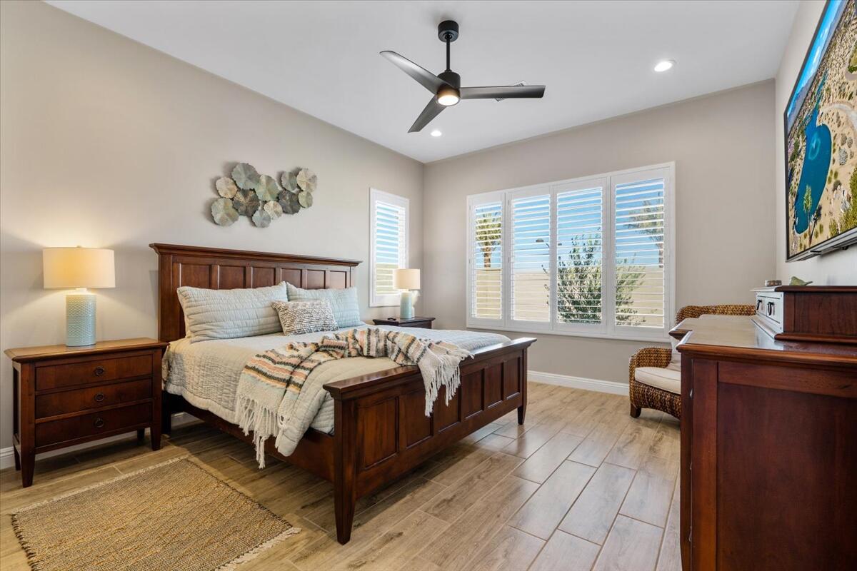 24 Claret Road Rancho Mirage, CA 92270 - Photo 16 of 34 a spacious bedroom with a large bed a chandelier and a window