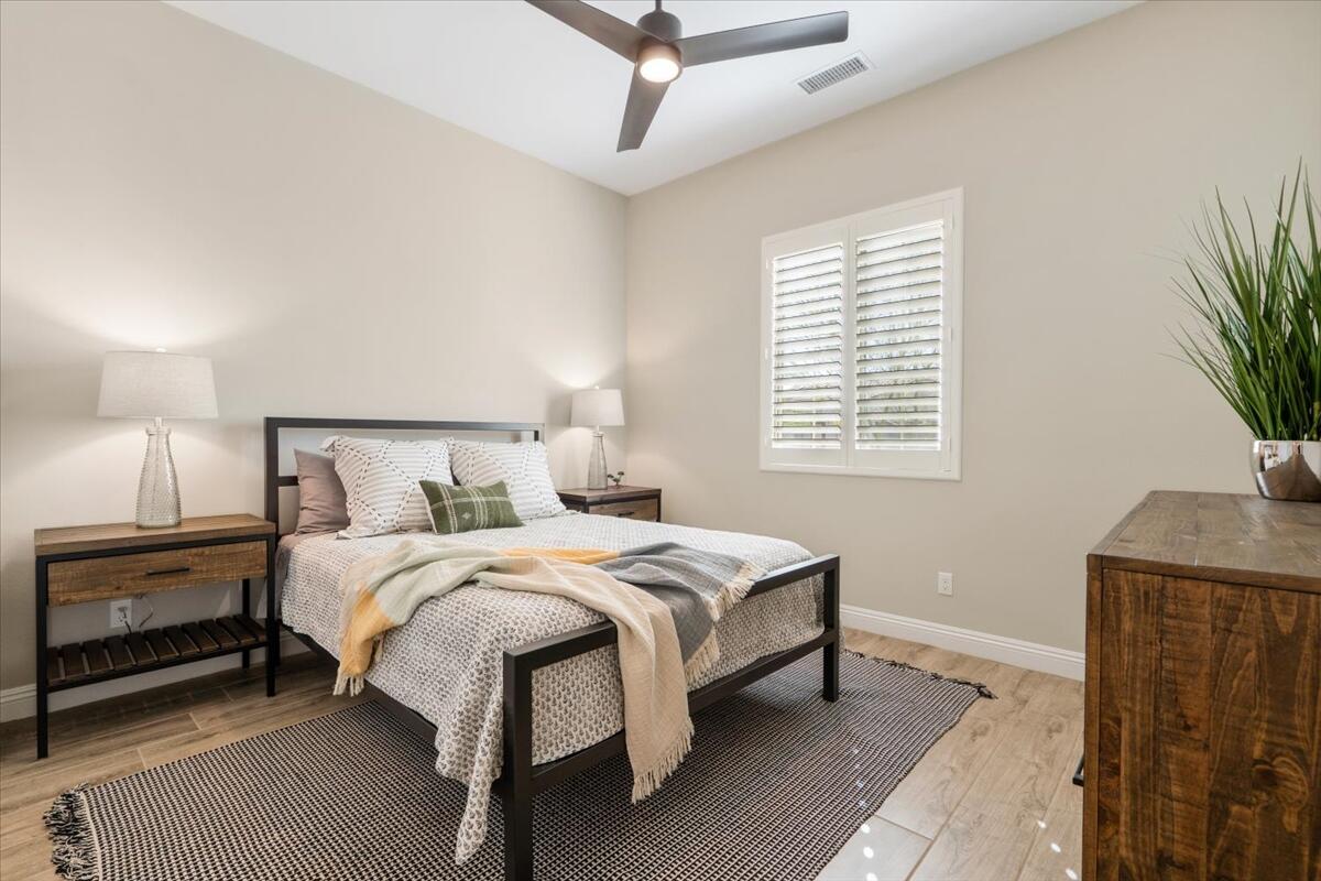 24 Claret Road Rancho Mirage, CA 92270 - Photo 19 of 34 a bedroom with a bed and a potted plant on the dresser
