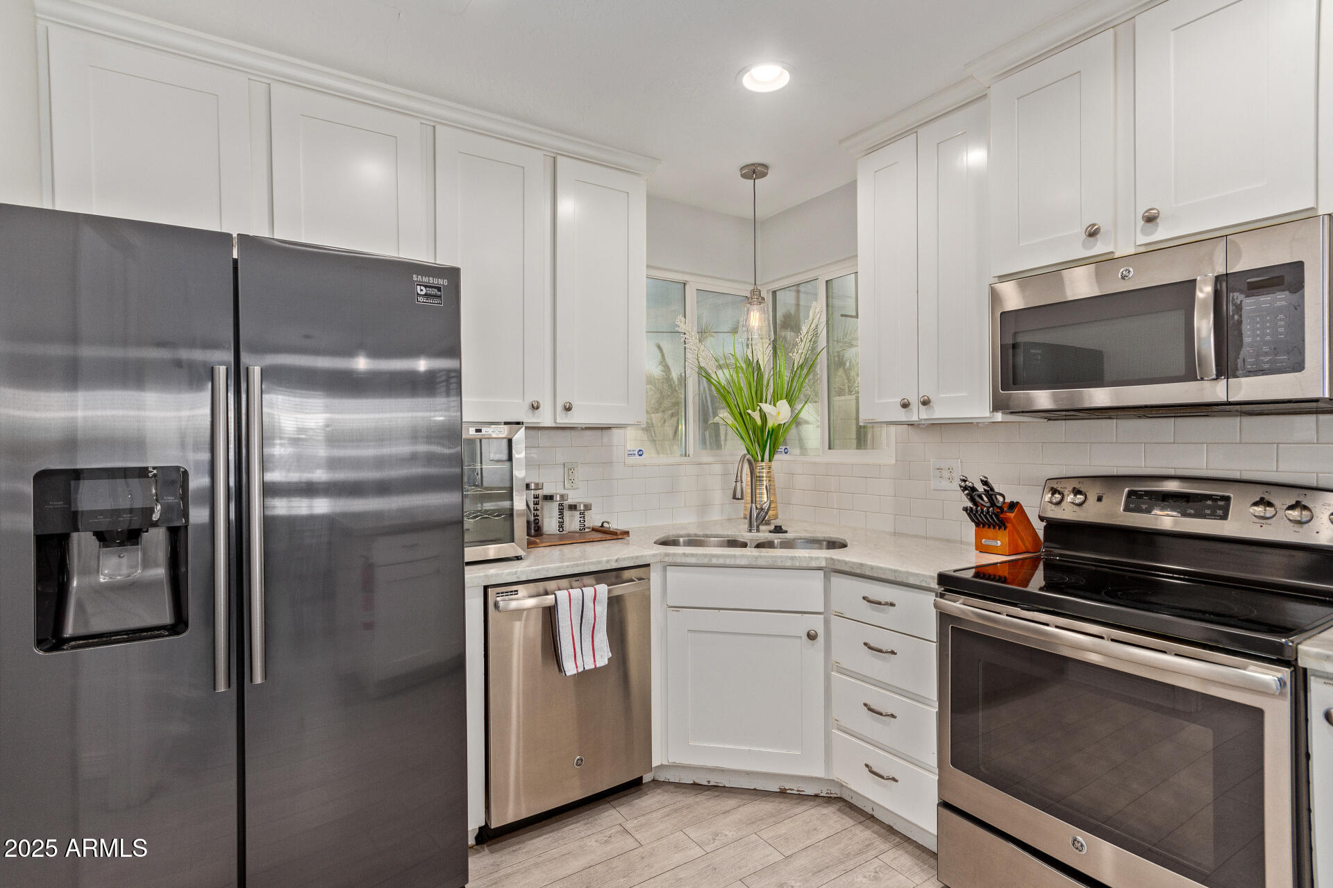3132 North 15th Avenue Phoenix, AZ 85015 - Photo 3 of 28 a kitchen with white cabinets stainless steel appliances and a sink