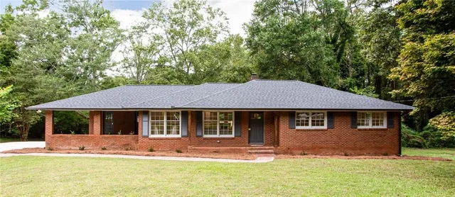 a front view of a house with a yard and trees