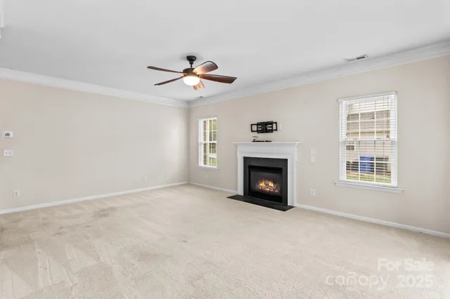 an empty room with windows and fireplace
