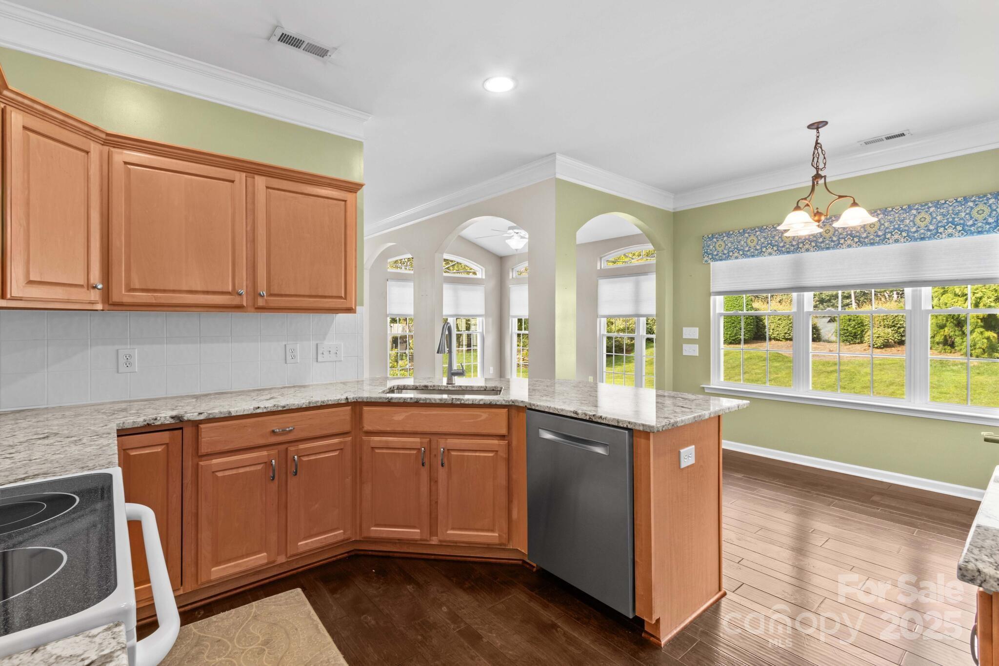 124 Elizabeth Hearth Road Mooresville, NC 28115 - Photo 24 of 48 a open kitchen with granite countertop a sink and dishwasher a stove top oven with wooden floor