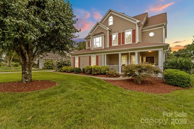 a front view of a house with garden and trees