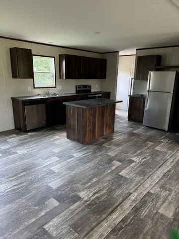 a kitchen with stainless steel appliances a refrigerator and a stove top oven