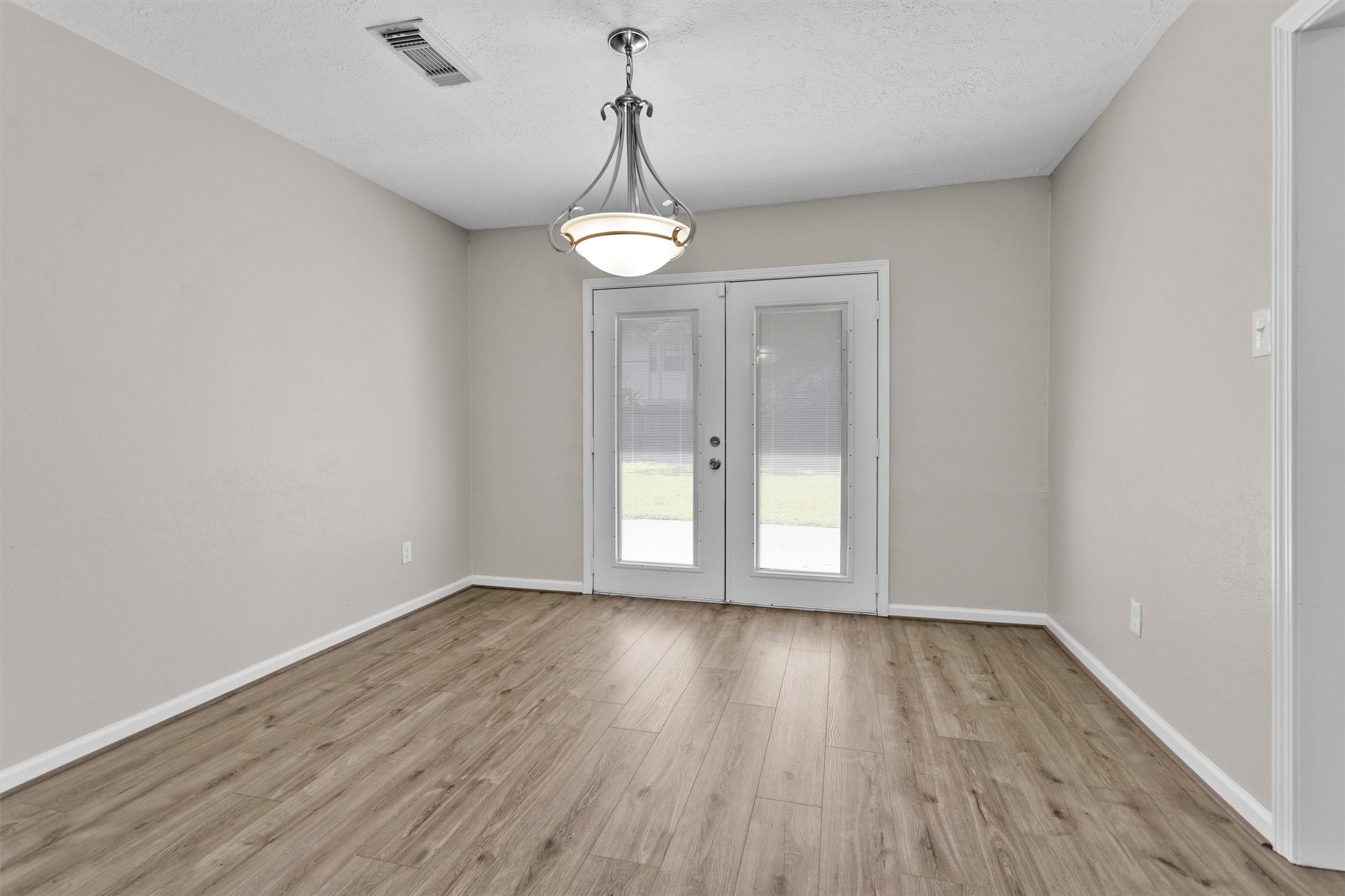 9115 Godstone Lane Spring, TX 77379 - Photo 11 of 46 Still in the dining room, double glass doors lead to the outdoor space, offering ample natural light. Ideal for a dining area or home office.