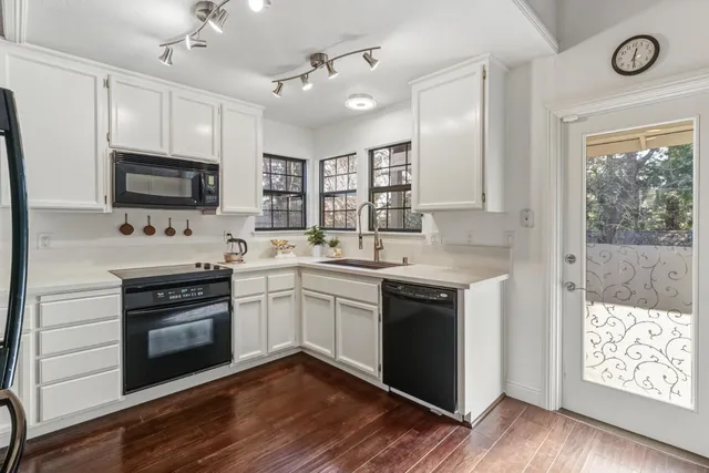 a kitchen with stainless steel appliances granite countertop a stove cabinets and a wooden floor