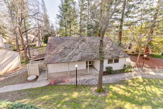 a view of a house with a yard and large tree