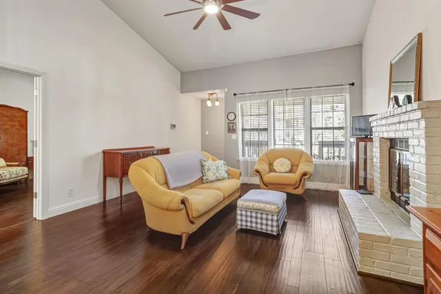 a living room with furniture a fireplace and wooden floor