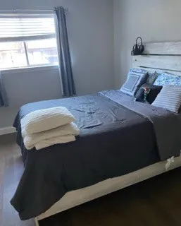 a bedroom with a bed wooden floor and window