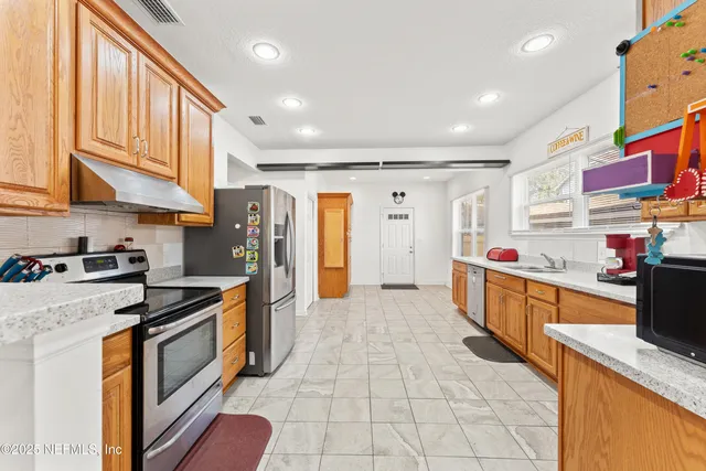 a kitchen with stainless steel appliances granite countertop a stove and a refrigerator