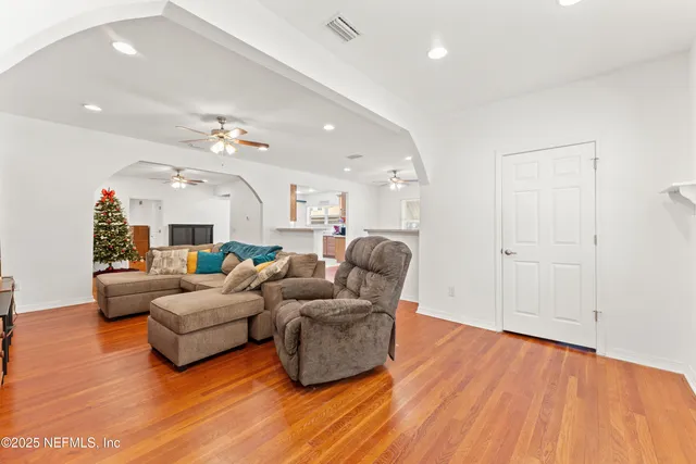 a living room with furniture and a wooden floor
