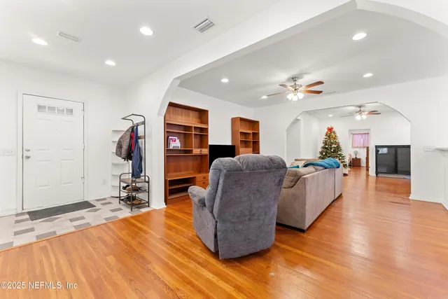 a living room with furniture a wooden floor and a flat screen tv