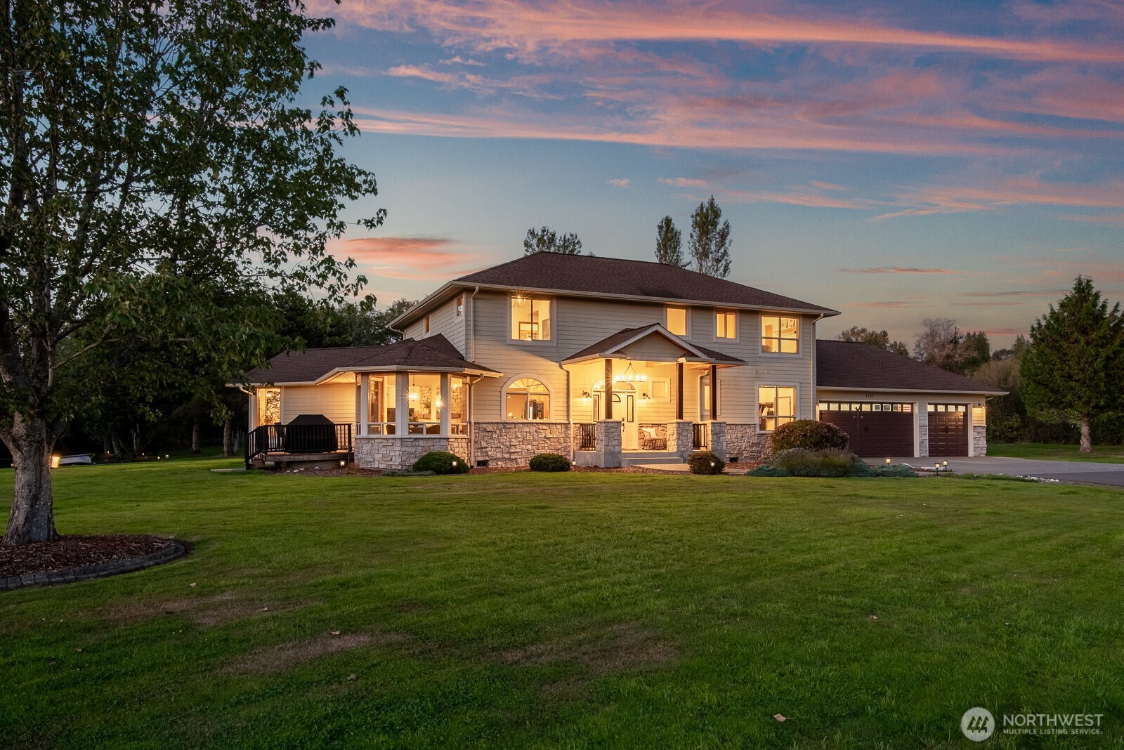a view of a big house with a big yard and large trees