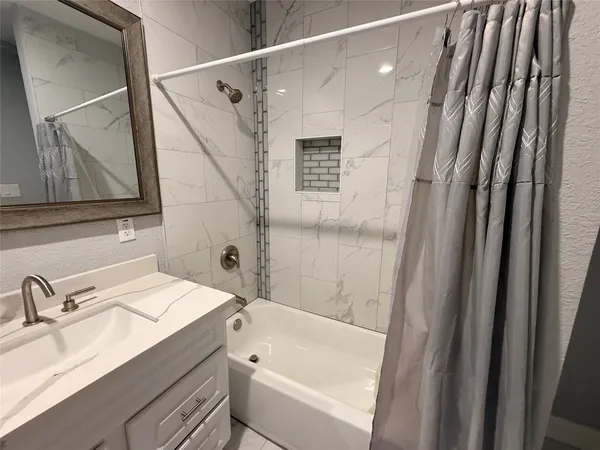a bathroom with a sink a mirror and a bathtub