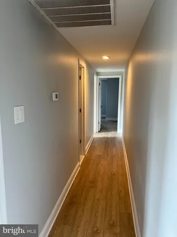 a view of a hallway with wooden floor