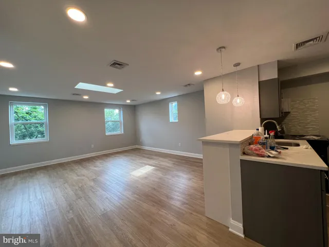 a view of a kitchen with a sink and dishwasher with wooden floor
