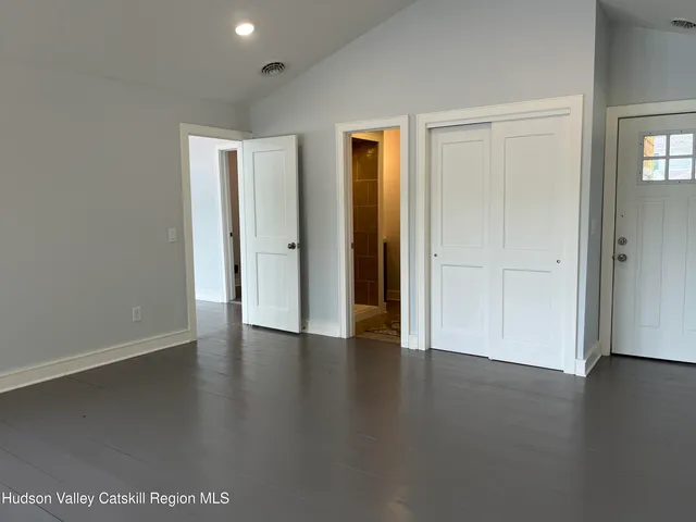 an empty room with wooden floor and closet area